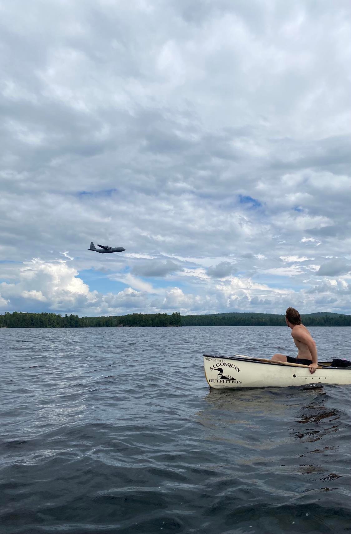 Plane flying overhead canoe